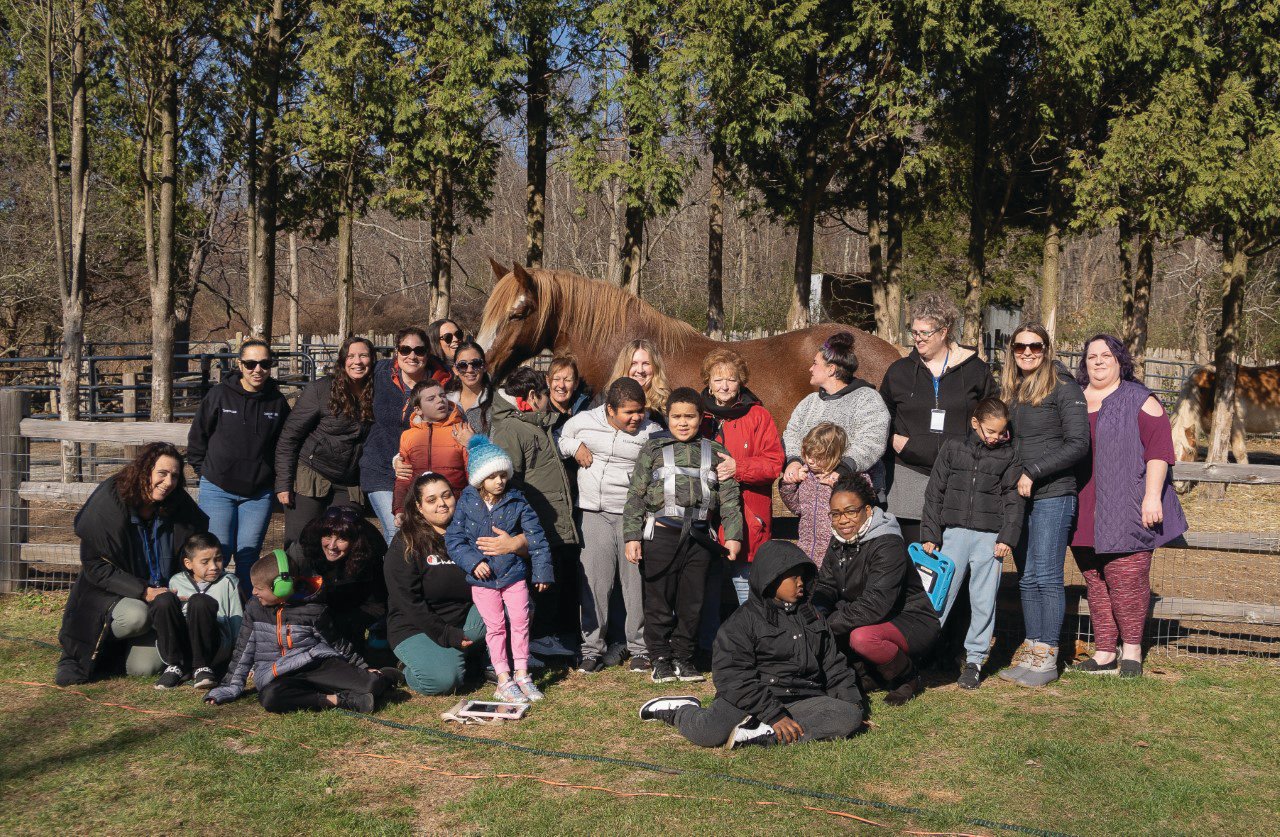 POSING WITH ROSIE THE HORSE: Stone Hill Elementary students, staff, caregivers and field trip bus drivers pose for a picture with Rosie, Equi Evolution’s largest horse, weighing in at almost 2,000 lbs. The students spent the late morning and early afternoon of Nov. 23 learning about the horses and farm through sensory activities.